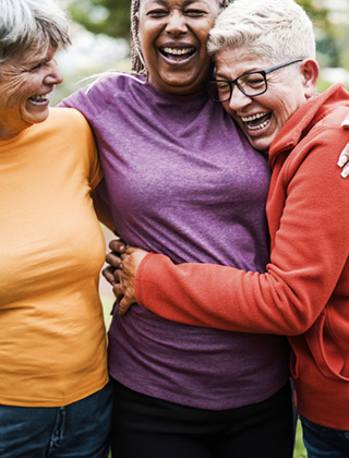 Three women smiling and hugging