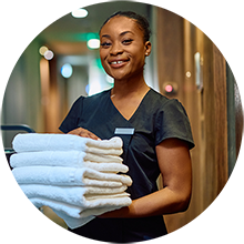 A housekeeping in the hallway holding white towels