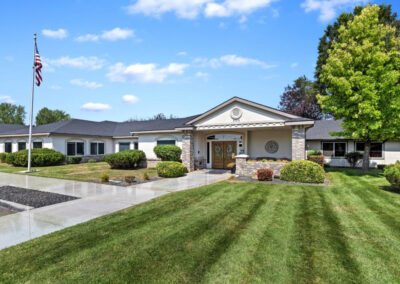 The front of the Autumn Wind care facility, trees and green grass
