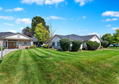 The front of the Autumn Wind care facility, trees and green grass