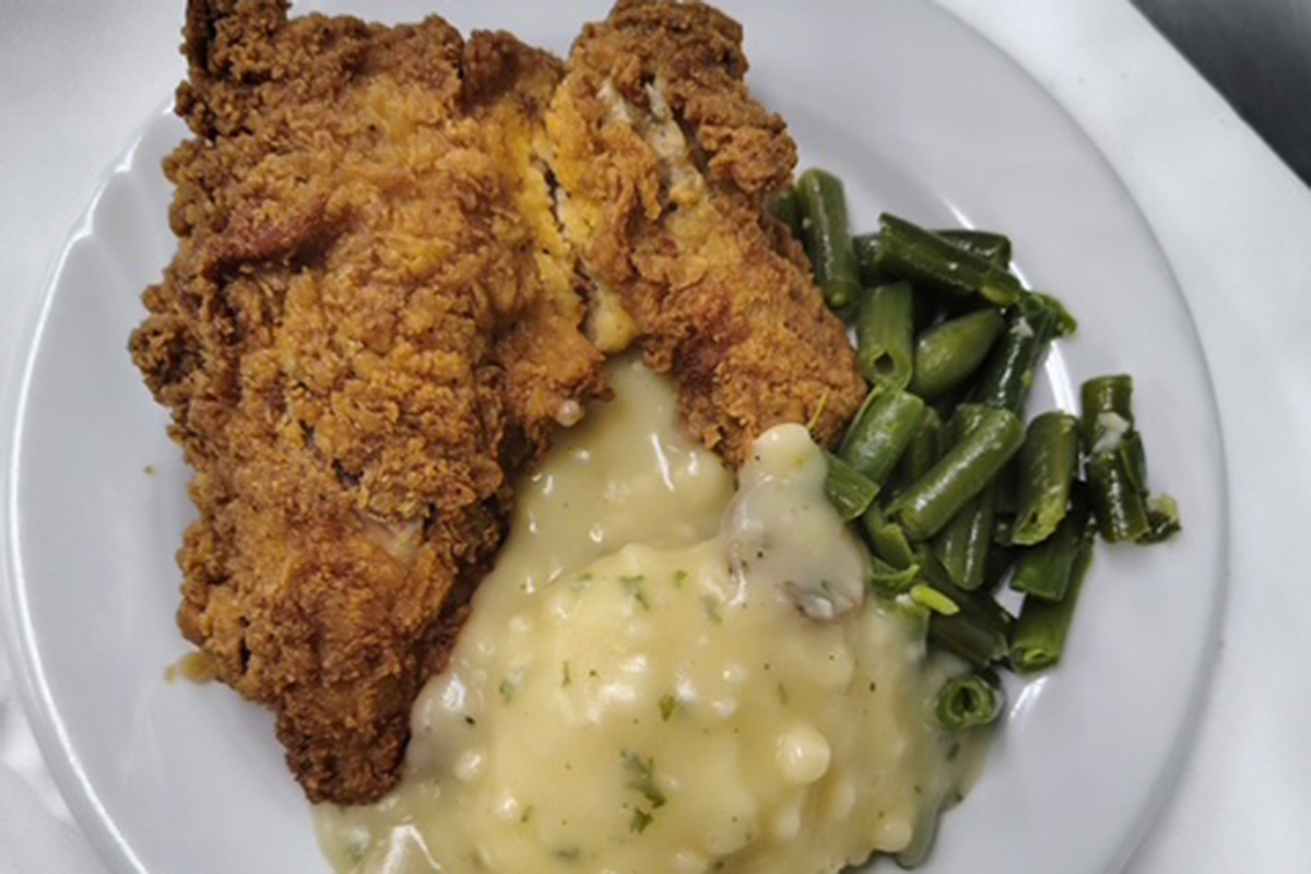 Fried chicken dinner with mashed potatoes and gravy and green beans at Autumn Wind Assisted Living and Memory Care.