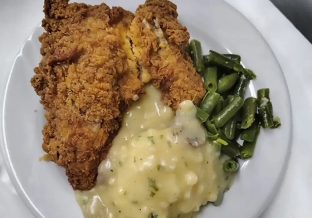 Fried chicken dinner with mashed potatoes and gravy and green beans at Autumn Wind Assisted Living and Memory Care.